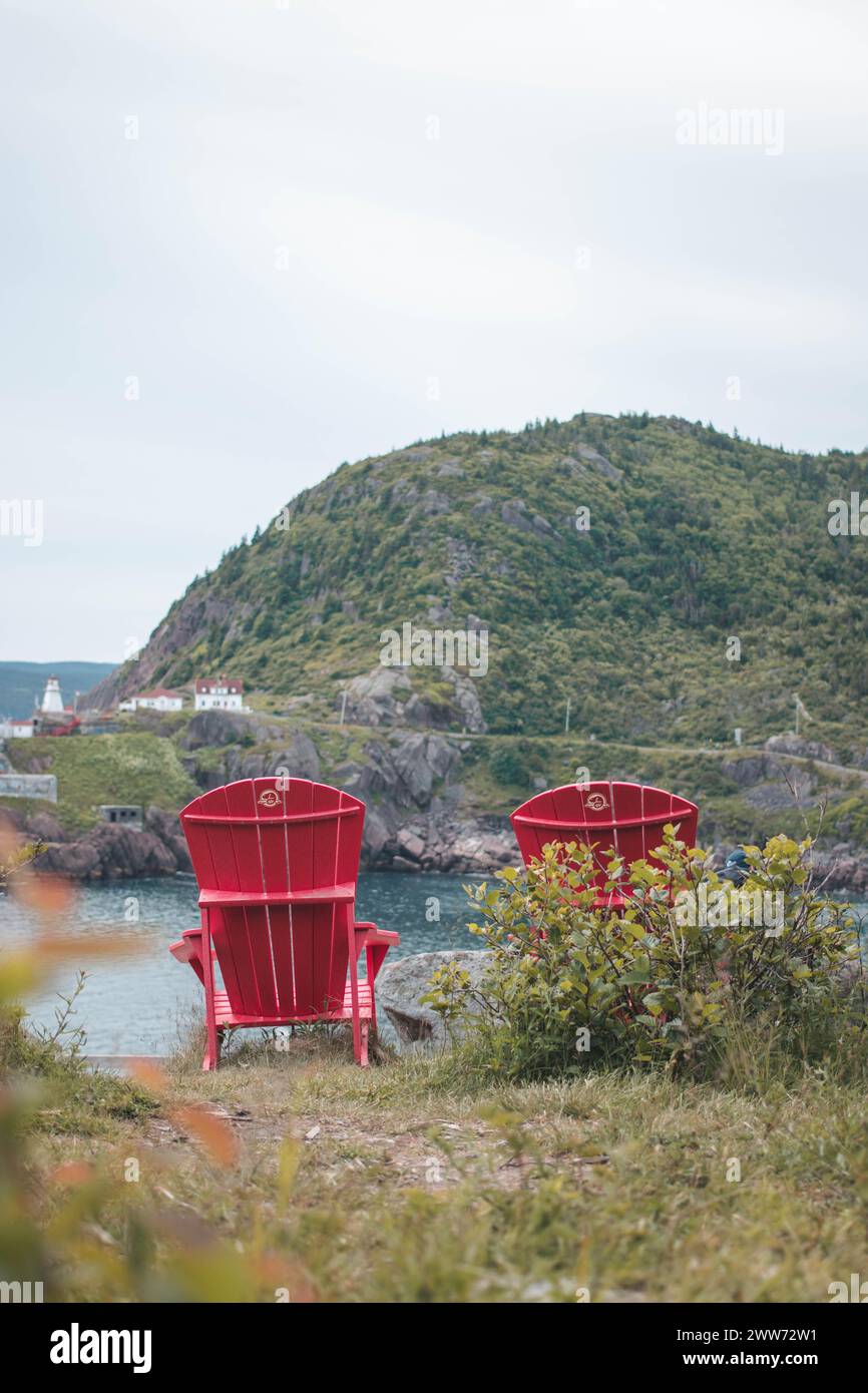 Two red chairs overlook the Battery in St. John's, Newfoundland Stock Photo