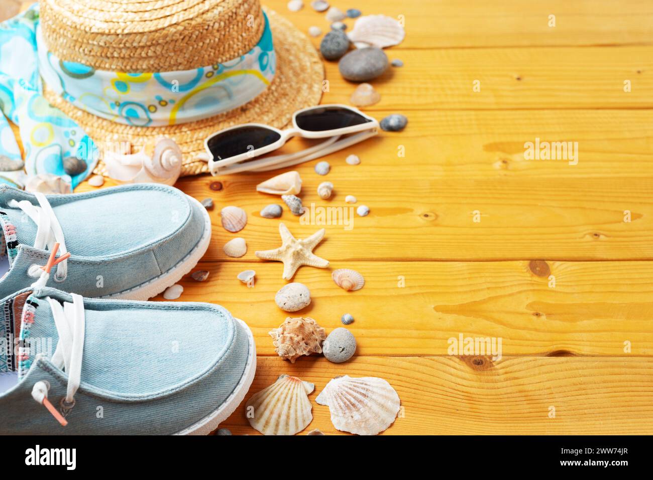 Holiday vacation travel planning background of straw hat, sunglasses, moccasins and shells on natural wood planks Stock Photo