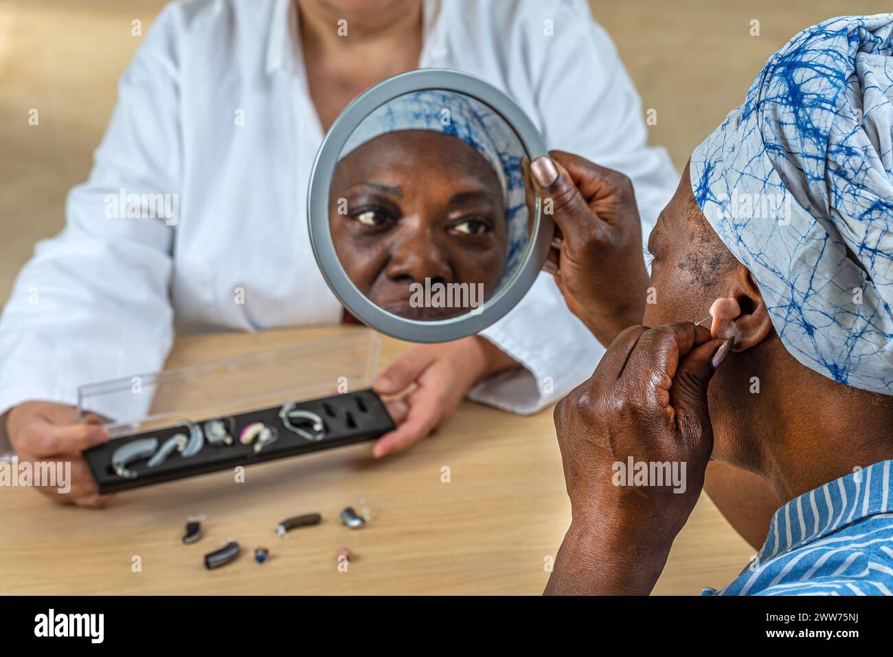 Patient trying different types of hearing aids. Stock Photo