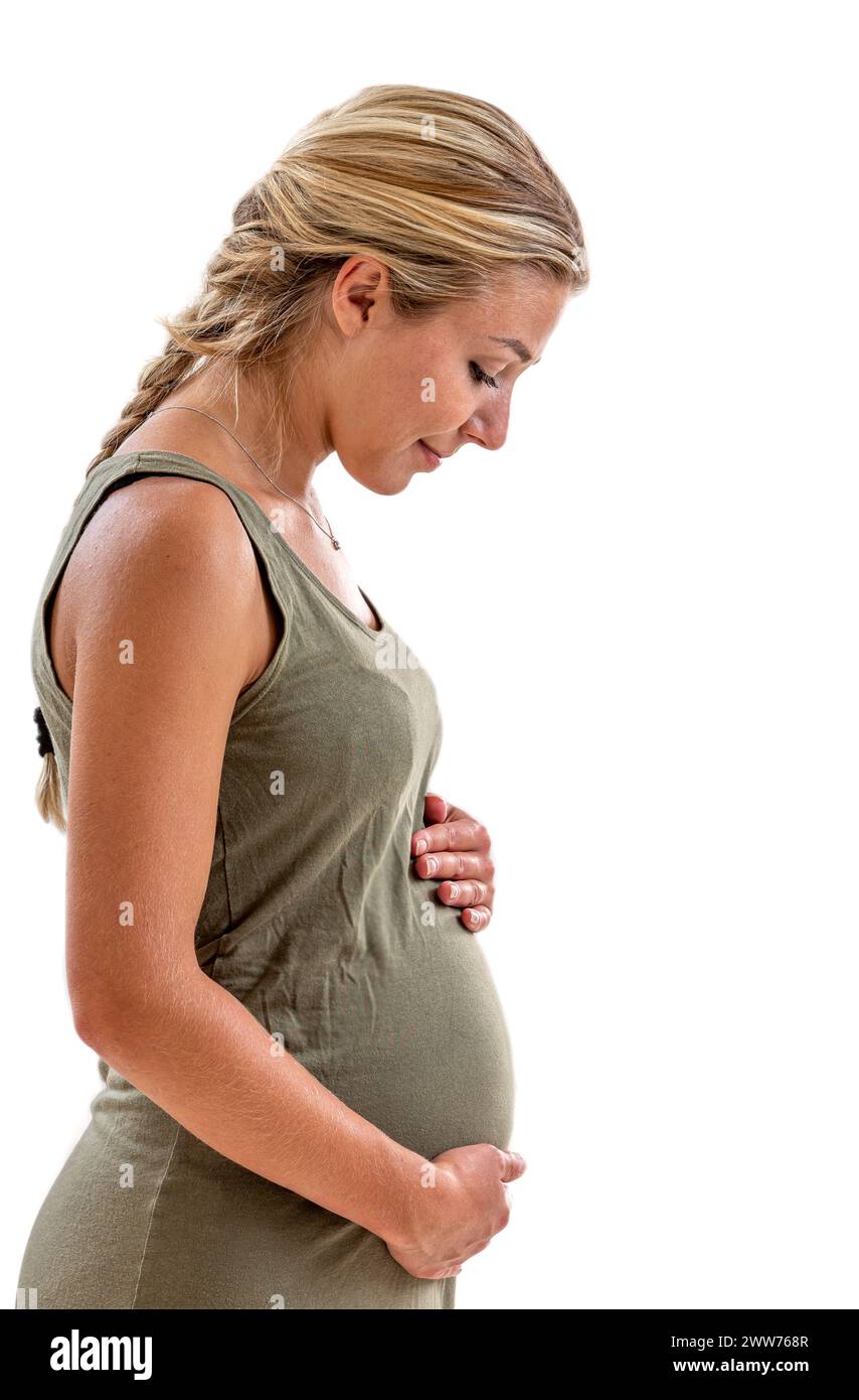 Pregnant woman in profile looking at her belly on a white background. Stock Photo