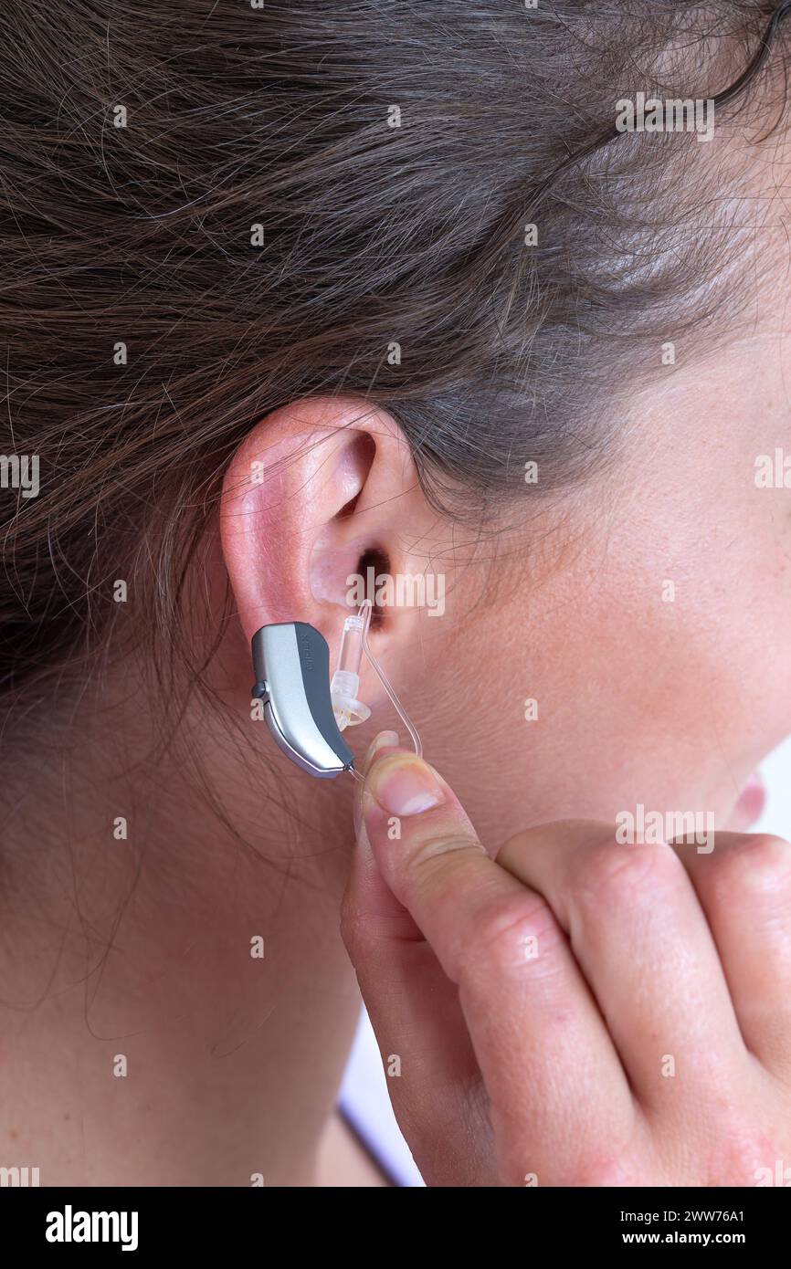 Close-up of fitting a hearing aid. Stock Photo