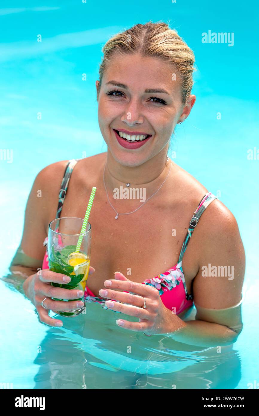 Portrait of a young blonde woman with tied hair. in quenching water. Stock Photo
