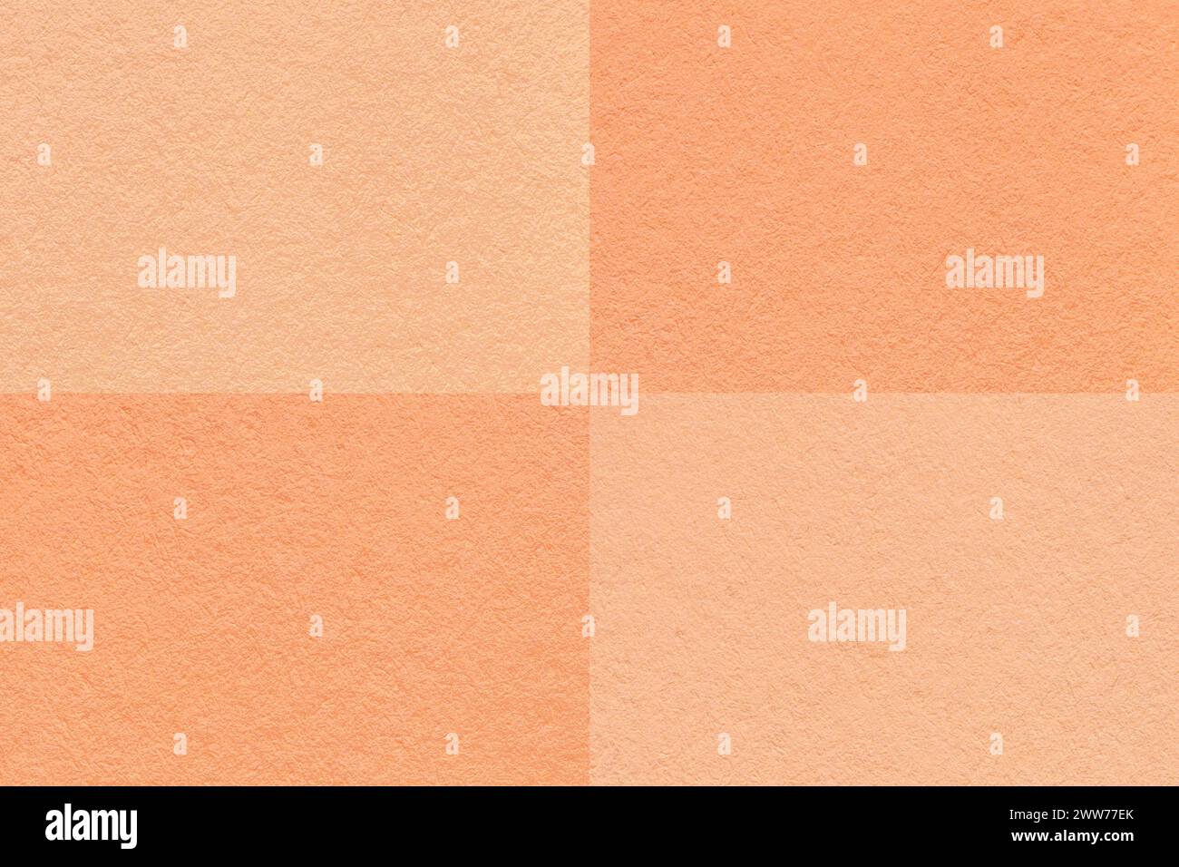 Color of the year 2024. Texture of craft peach fuzz and coral paper background with cells pattern, macro. Structure of vintage dense kraft cardboard. Stock Photo