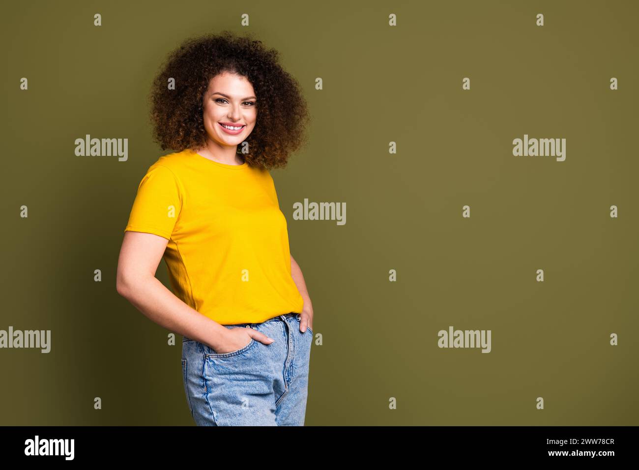 Portrait of glad young woman in yellow t shirt and jeans candid model ...