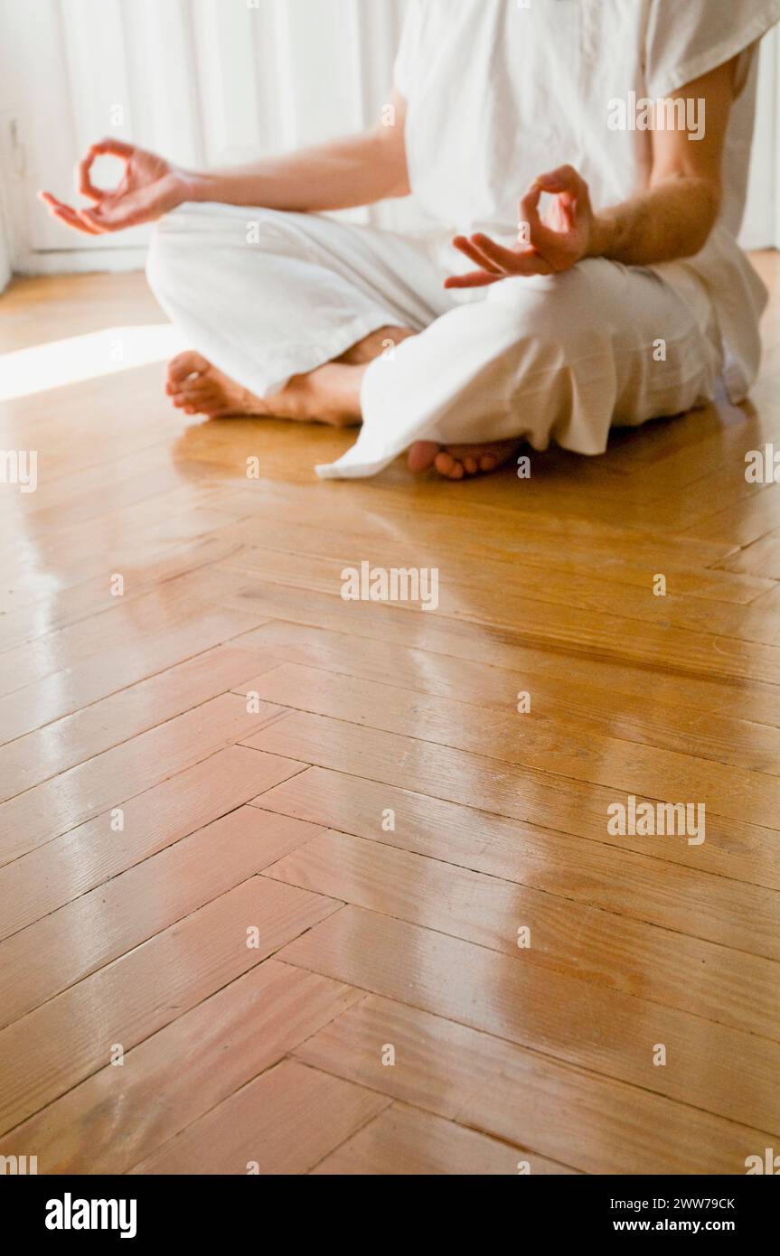Man practicing yoga, sitting in the lotus position. Stock Photo