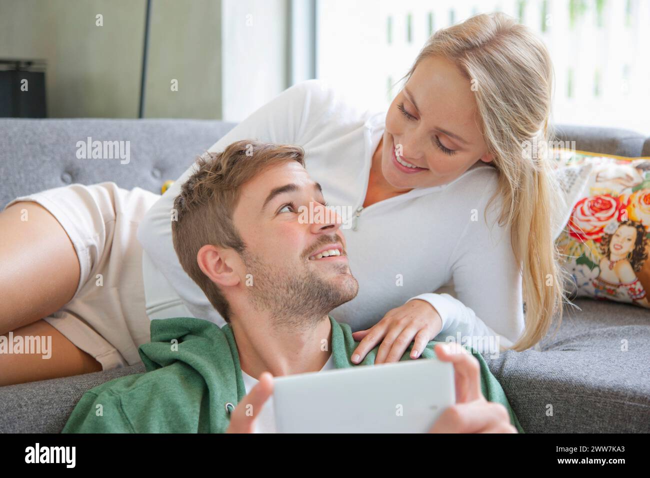 Couple on Sofa Using Smartphone Stock Photo