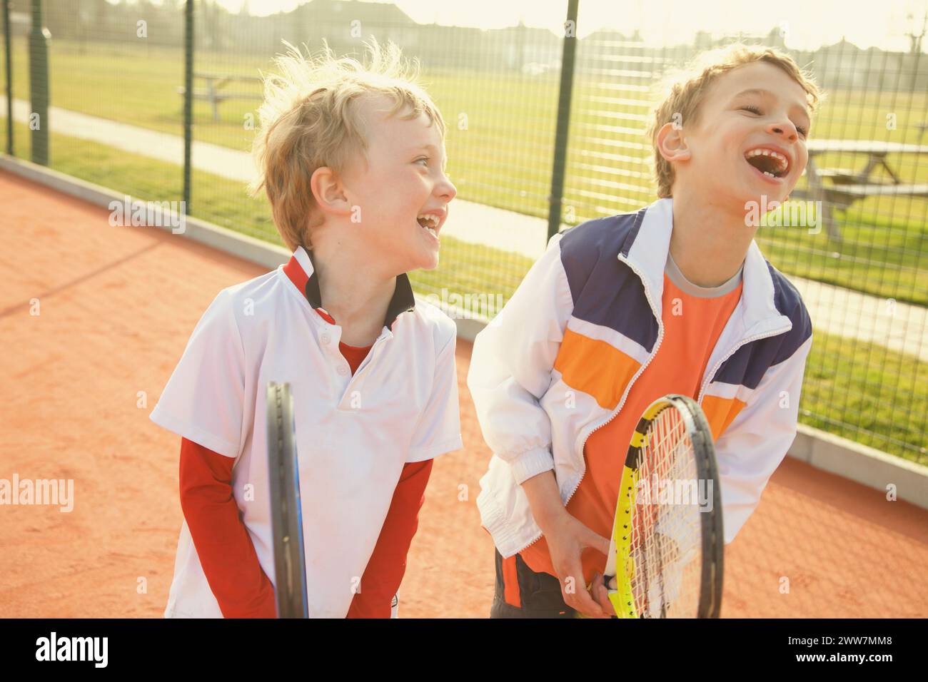 Two Young Boys Holding Tennis Rackets Smiling Stock Photo - Alamy