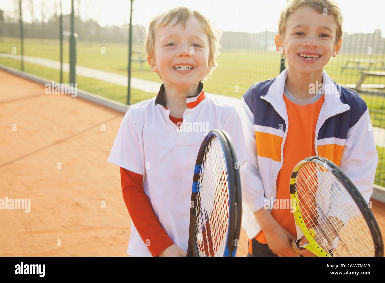 Two Young Boys Holding Tennis Rackets Smiling Stock Photo - Alamy