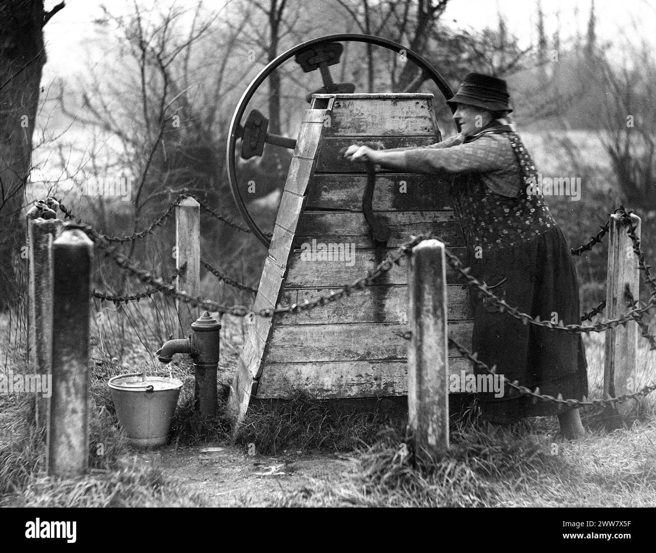 Woman pumping water from public water pump in Kent, England, Uk 1932 Stock Photo