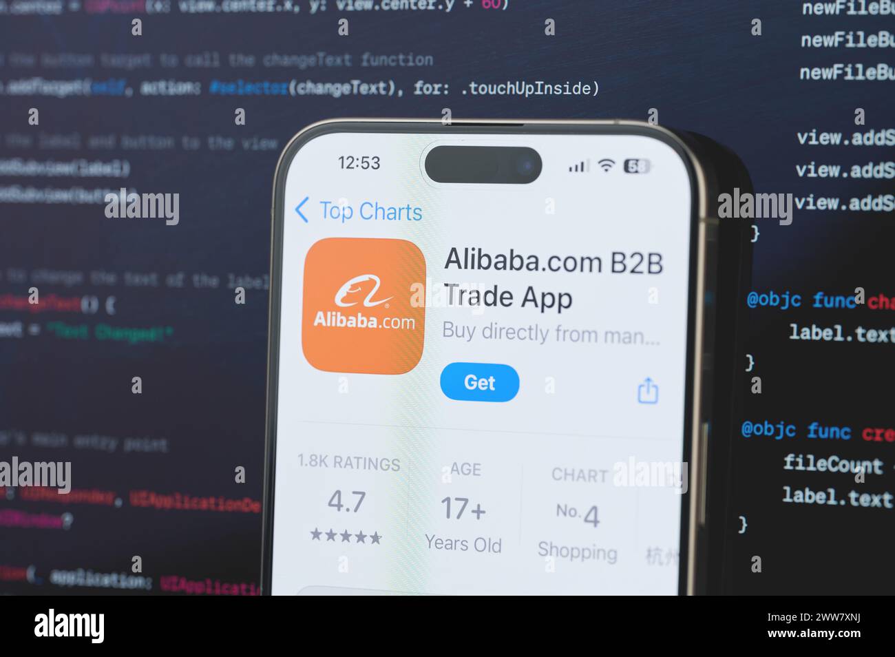 New York, USA - February 23, 2024: Alibaba on iphone screen in blurred code programming background Stock Photo