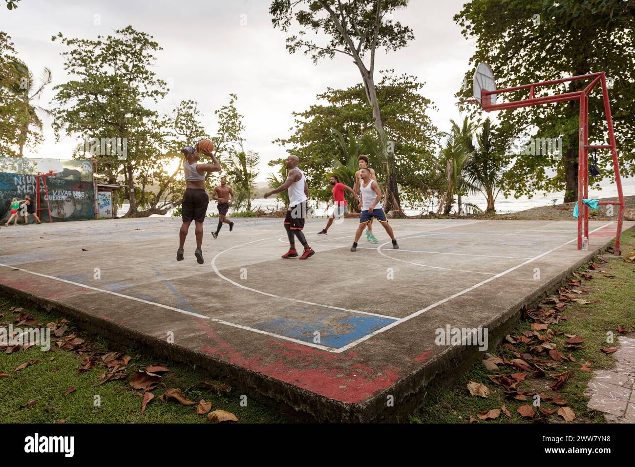 Locals playing basketball with tourists on a local basketball court near the beach in Puerto Viejo on Caribbean coast, Costa rica Stock Photo