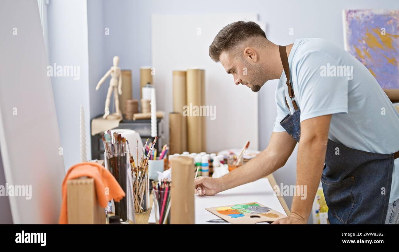A thoughtful man with a beard painting in a bright art studio Stock ...