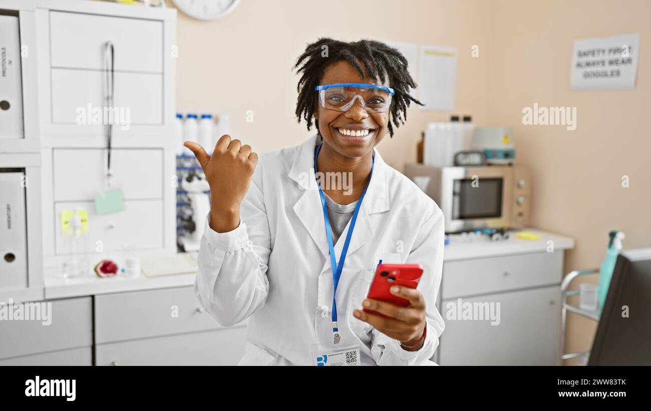Young african american woman with dreadlocks and lab coat in a ...