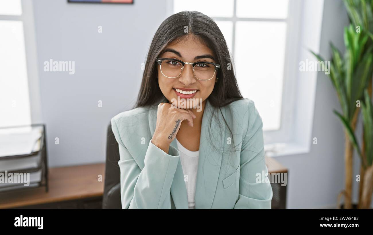 Smiling indian woman with glasses, long hair, in office wearing a light ...