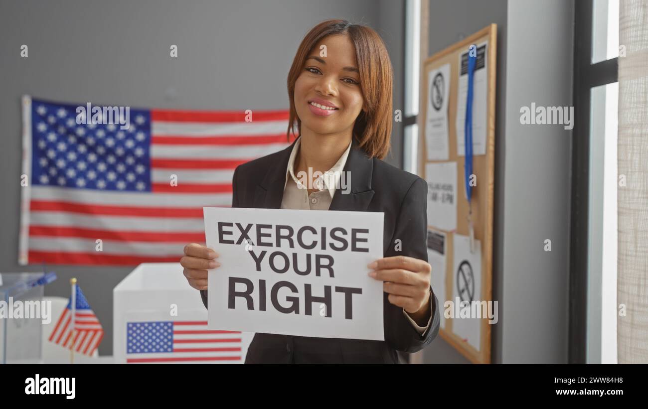African american woman holding a voting rights sign indoors with us flag background Stock Photo