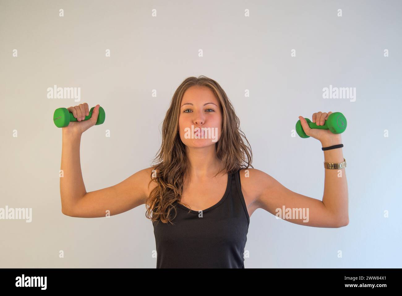 Young woman doing exercise with weights. Stock Photo