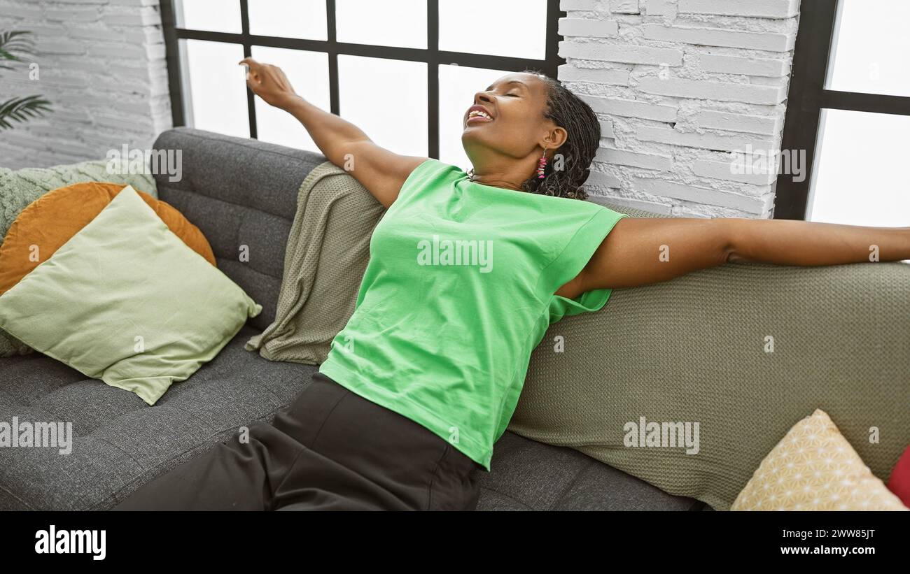African american woman relaxing on sofa in a modern living room ...