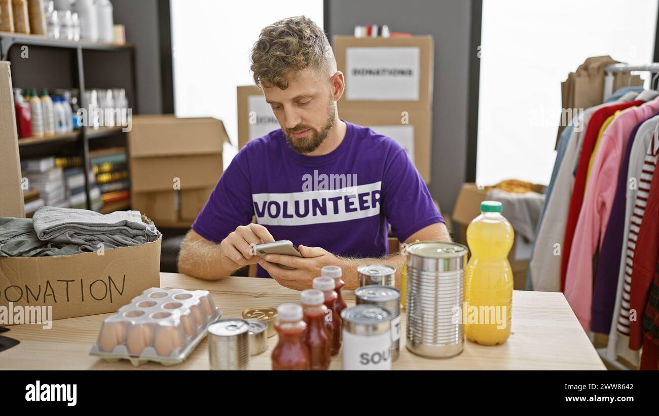 Young man volunteer sorting donations in warehouse using smartphone