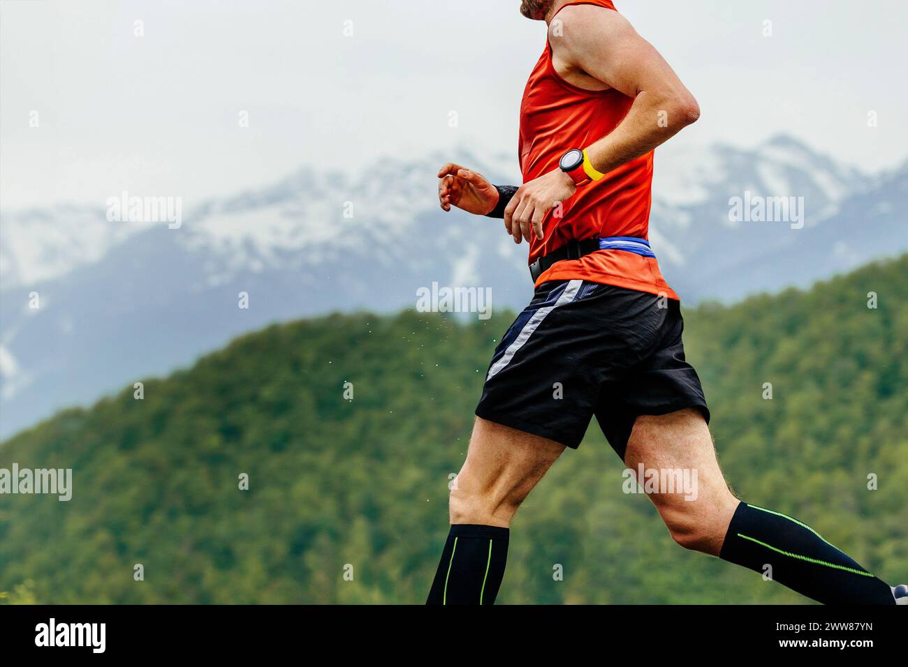 close-up man running in background of mountains and forests, with timer ...