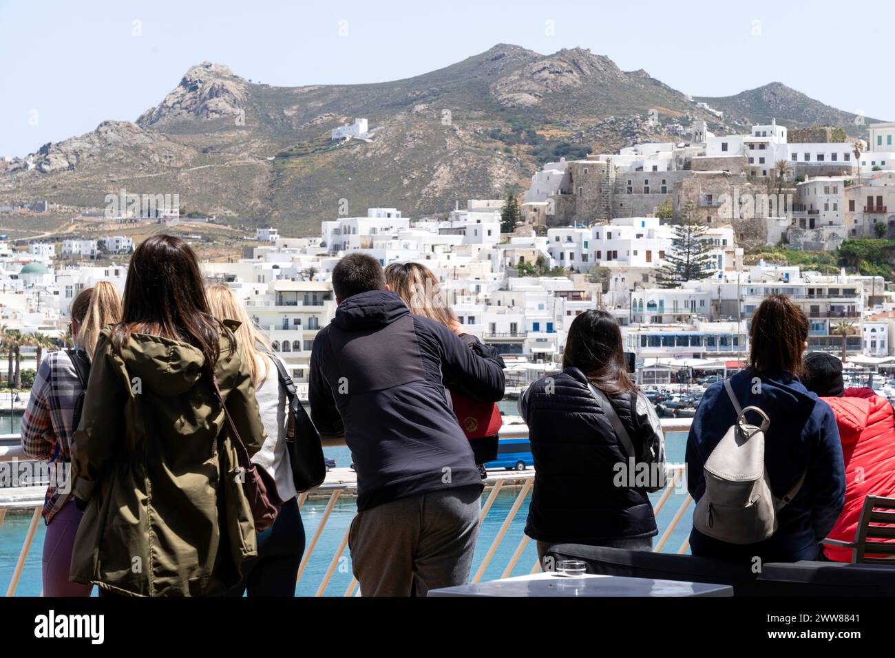 Young tourists on board a ferry are observing the coast of Naxos island and the Chora town. They all are of caucasian descent and in their 20's. Stock Photo