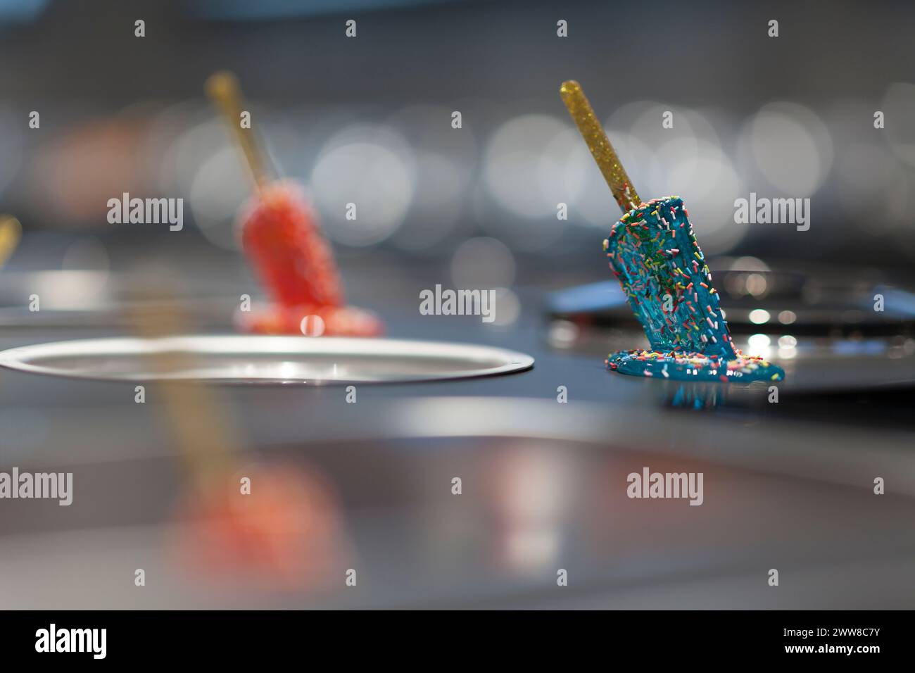 Close up on a melted popsicle on the iron table of a ice cream maker. Stock Photo