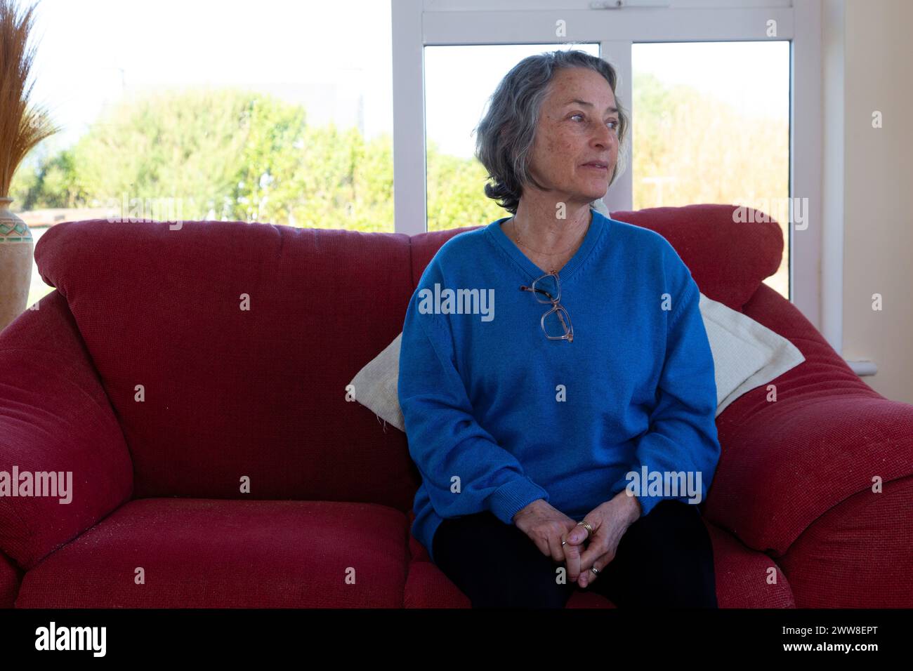 Senior woman alone of sofa Stock Photo