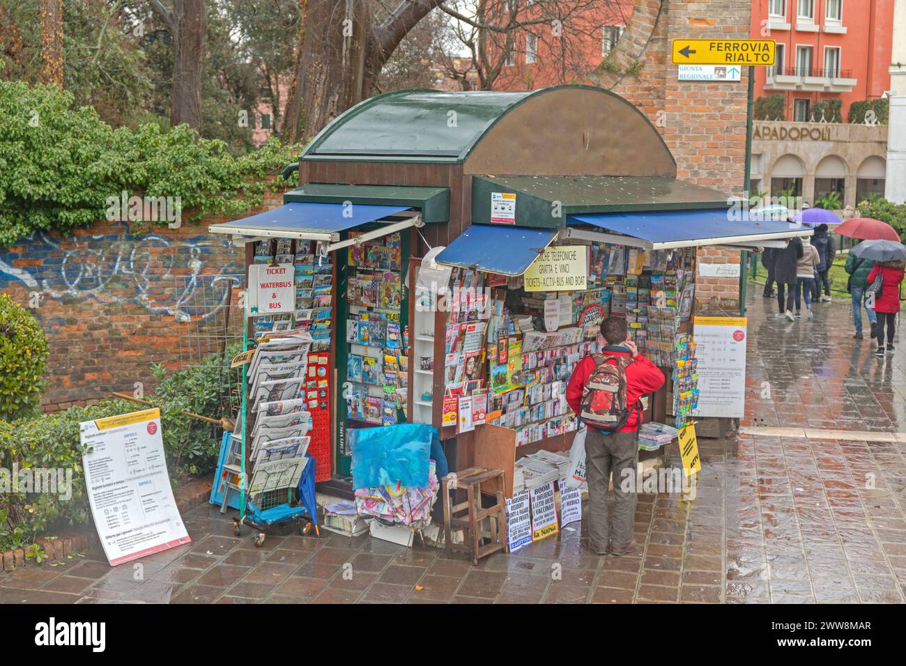 Vence, Italy - February 3, 2018: Newspapers Magazines Tickets Mobile Phone Sim Cards at Kiosk Shop Rainy Winter Day. Stock Photo