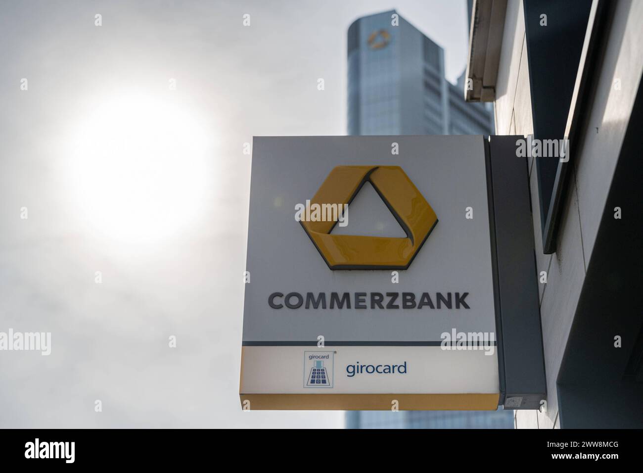 Commerzbank-Schild mit Tower im Hintergrund 21.03.24, Frankfurt: Symbolfoto, Illustrationsbild, Symbolbild, Illustrationsfoto Commerzbank-Schild mit Tower im Hintergrund Vor der Kulisse des teilweise sichtbaren Commerzbank Towers präsentiert sich das Schild einer Commerzbank-Filiale, symbolisch für die Verbindung von lokalem Service und globaler Präsenz des Finanzinstituts in der Skyline der Stadt. Frankfurt Hessen Germany *** Commerzbank sign with tower in the background 21 03 24, Frankfurt Symbol photo, illustration image, symbol image, illustration photo Commerzbank sign with tower in the b Stock Photo