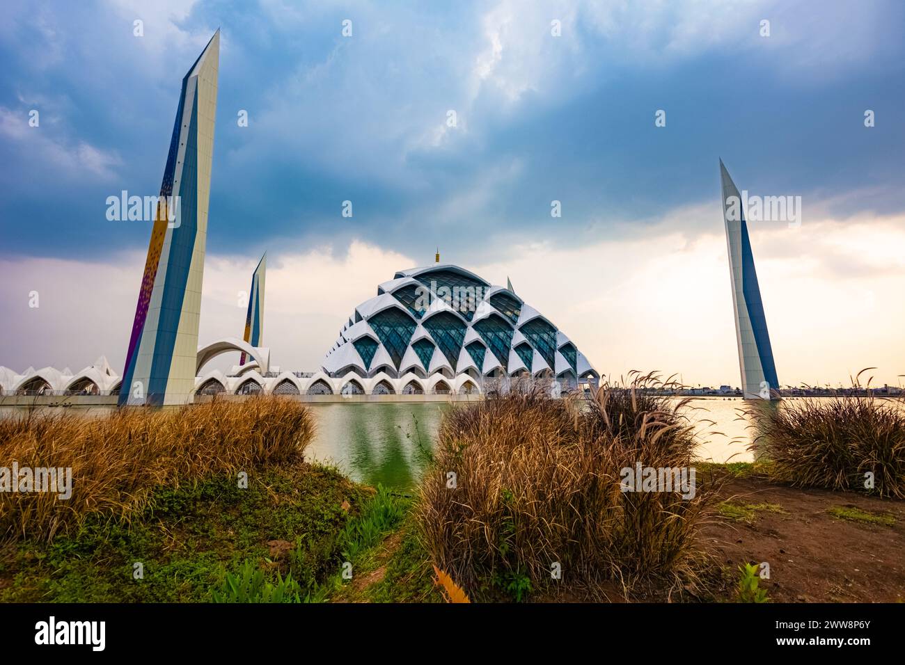 Bandung, Indonesia - 4th Nov 2023: Al Jabbar Great Mosque at sunset (golden hour) with lamps and reflections in the pond Stock Photo