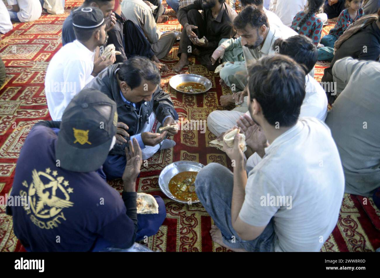 Faithful Muslims are breaking the fast (Iftar) under the supervision of ...