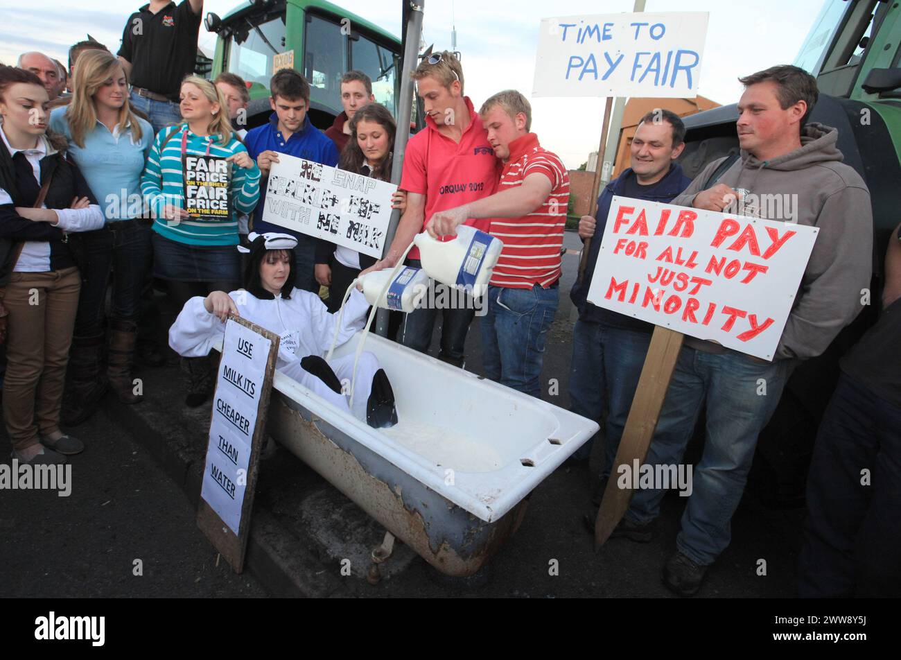 22/07/12..Dressed in a cow suit, and with a sign saying: 'USE MILK ITS CHEAPER THAN WATER', Katie Weaver, 25, from Market Drayton, sits in a bath full Stock Photo