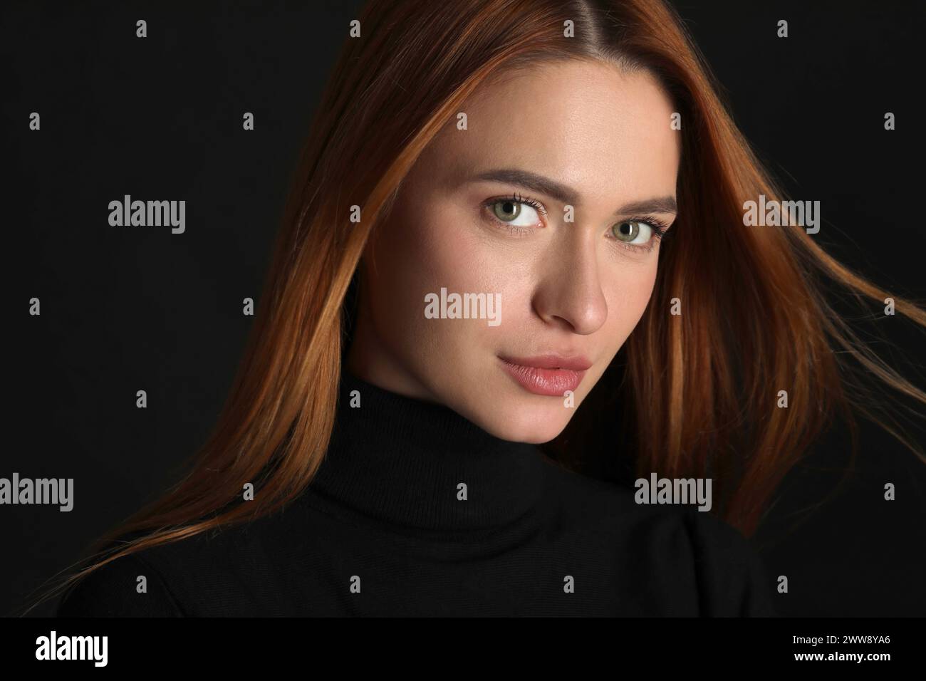 Evil eye. Young woman with scary eyes on black background Stock Photo