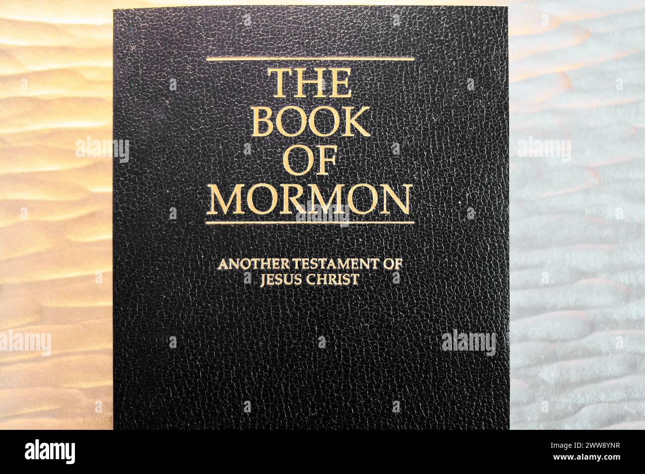 A close view of the sacred book of the Mormons, showing the embossed golden title on a textured black cover, symbolizing spirituality and faith. Stock Photo
