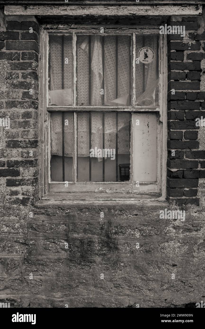 Atmospheric old derelict red brick shed window with peeling paint and ...