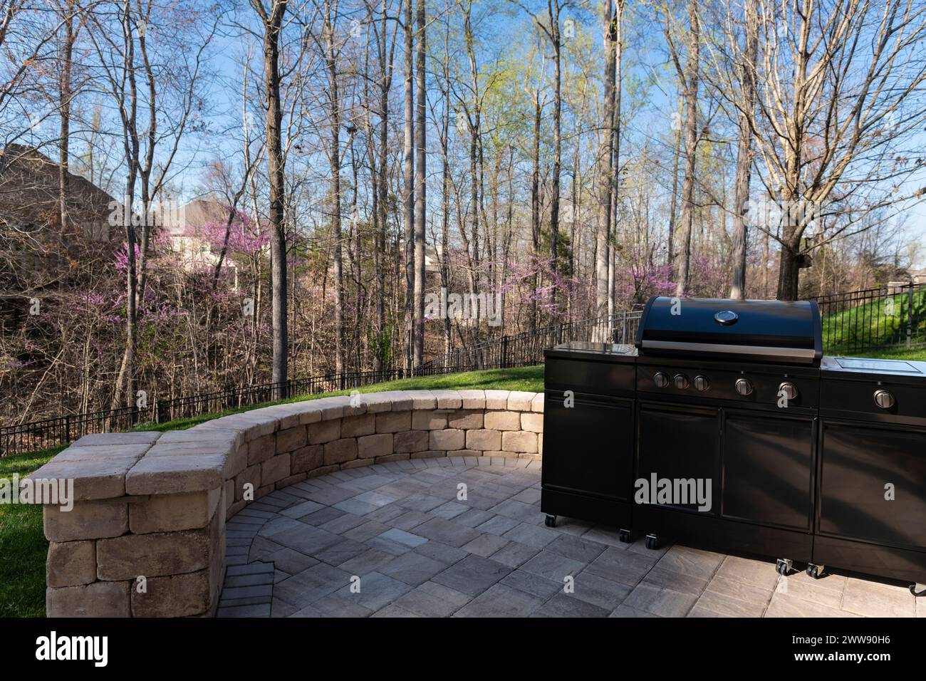 Backyard garden view with a black gas grill with lid closed in