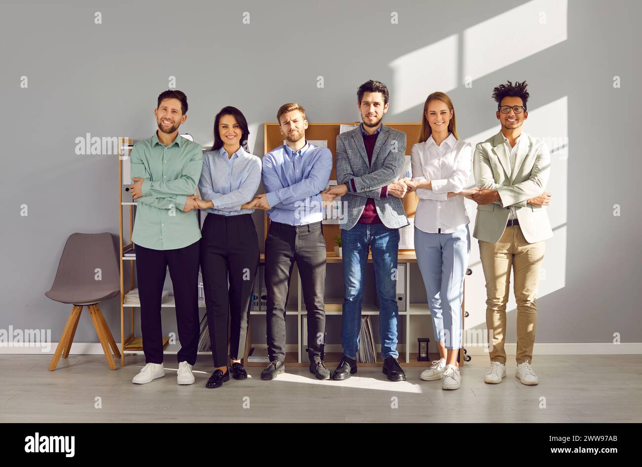 Group smiling people standing in row holding hands in office Stock ...