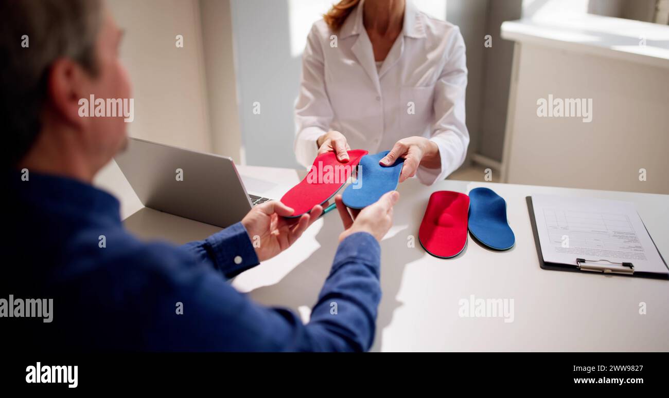 Orthopedist Doctor With Orthopedic Shoe Insole Consulting Patient Stock Photo