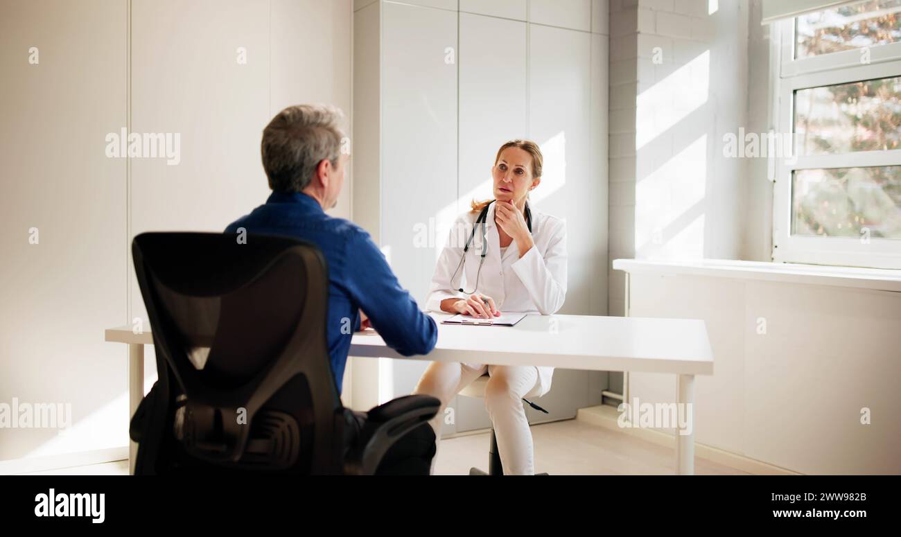 Medical Doctor And Patient In Hospital. Man Talking To Physician Stock Photo