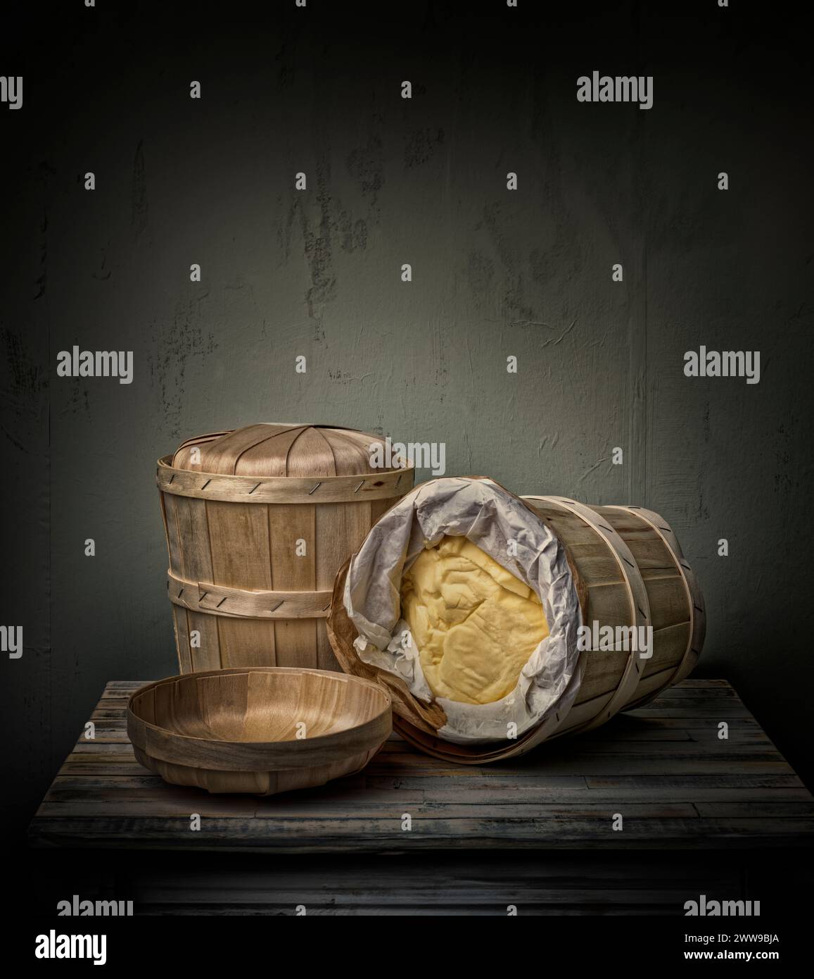 Two bamboo barrels, bowl, and tray on wooden table Stock Photo