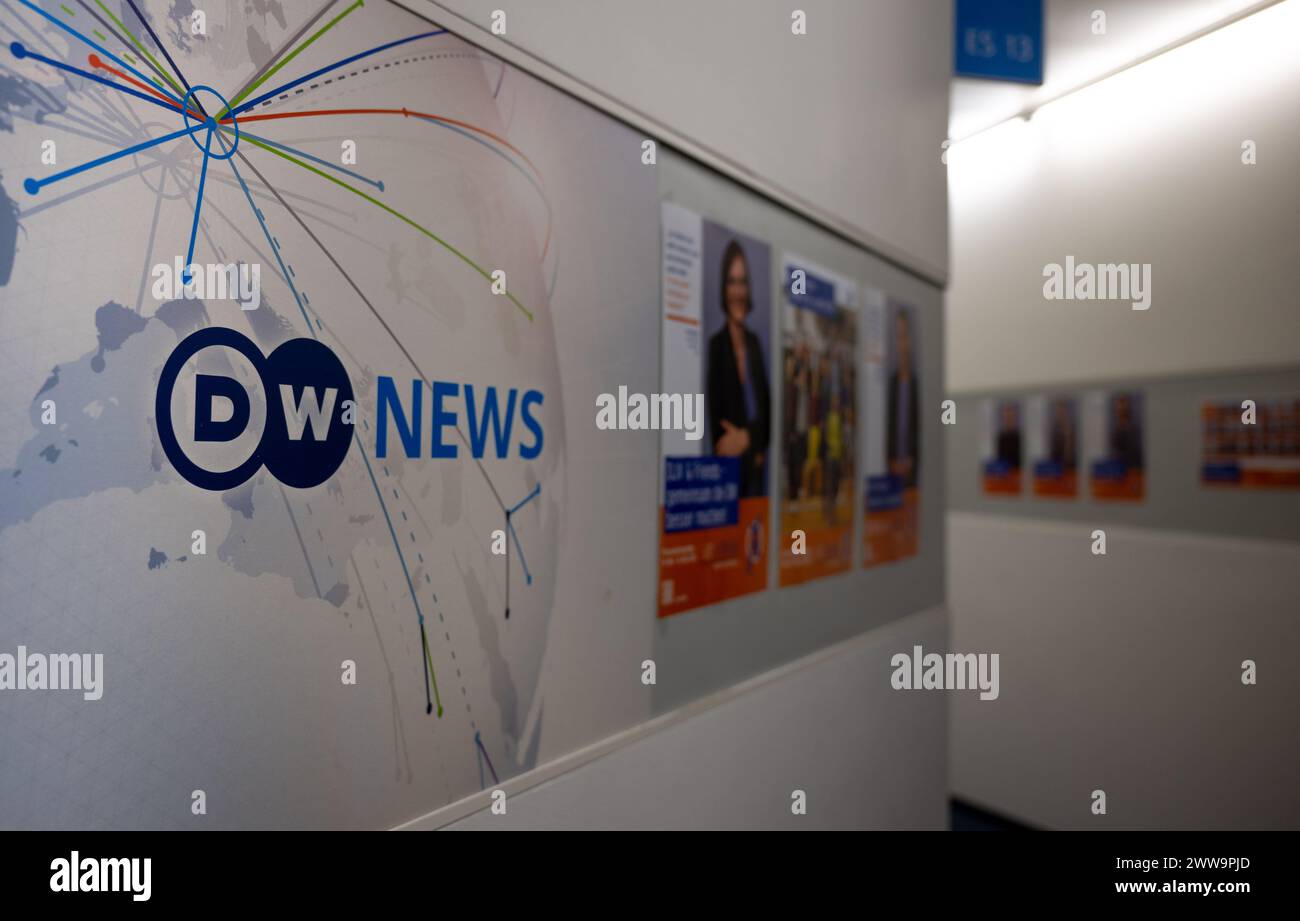 Berlin, Germany. 22nd Mar, 2024. A logo with the inscription DW News hangs in a corridor in the capital city headquarters of the broadcaster Deutsche Welle. DW is a public-law institution and works in three media: television, radio and the Internet. Credit: Monika Skolimowska/dpa/Alamy Live News Stock Photo