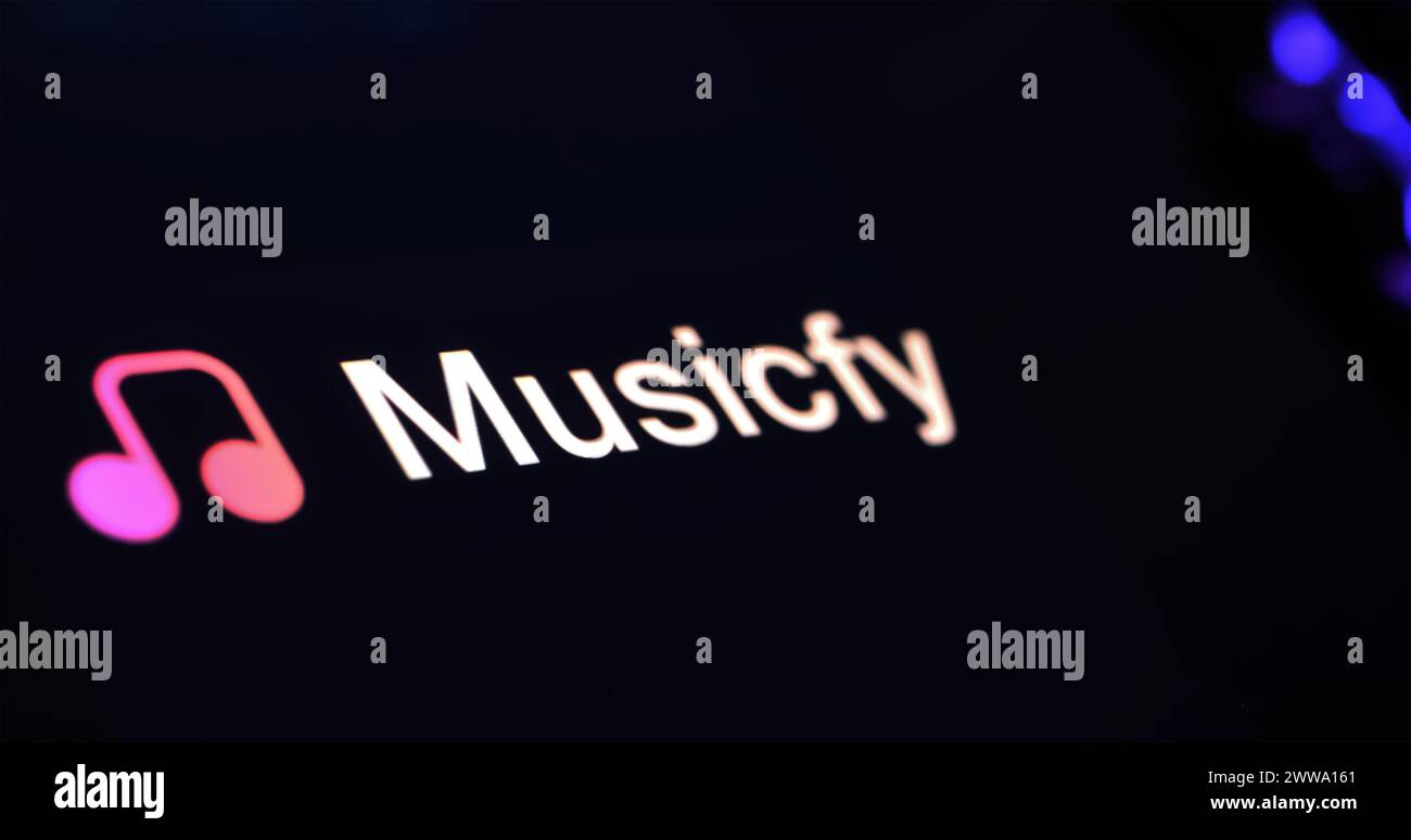 Viersen, Germany - March 9. 2024: Closeup of Smartphone with logo lettering of AI voice song generator Musicfy on computer keyboard Stock Photo