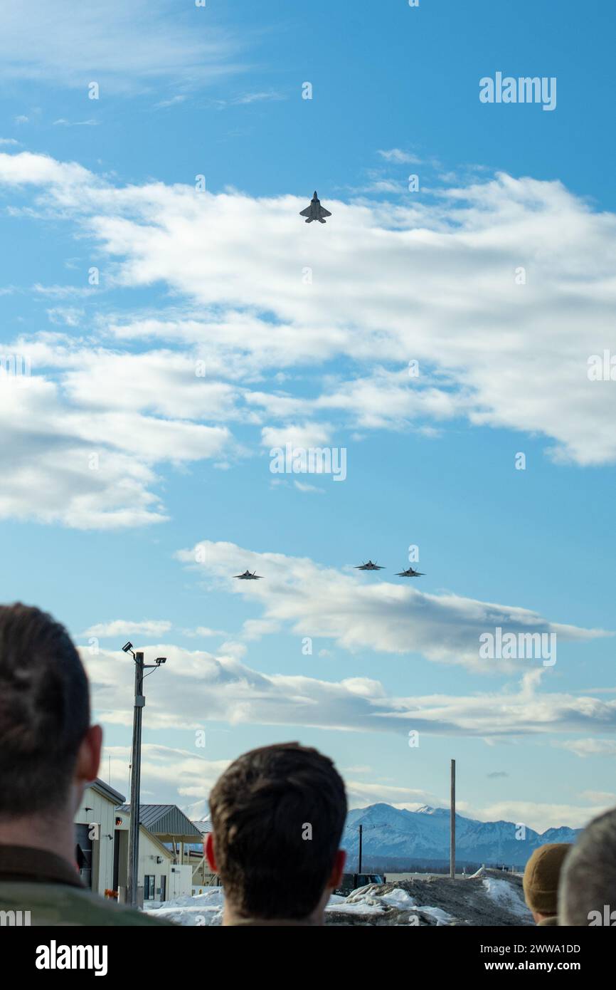 Members of the 3rd Wing and 90th Fighter Generation Squadron view a missing man formation flyover in remembrance of Staff Sgt. Charles A. Crumlett at Joint Base Elmendorf-Richardson, Alaska, March 22, 2024. The missing man formation is a military tradition which dates back to World War II and is one of the highest forms of paying respects to fallen service members. (U.S. Air Force photo by Senior Airman Patrick Sullivan) Stock Photo