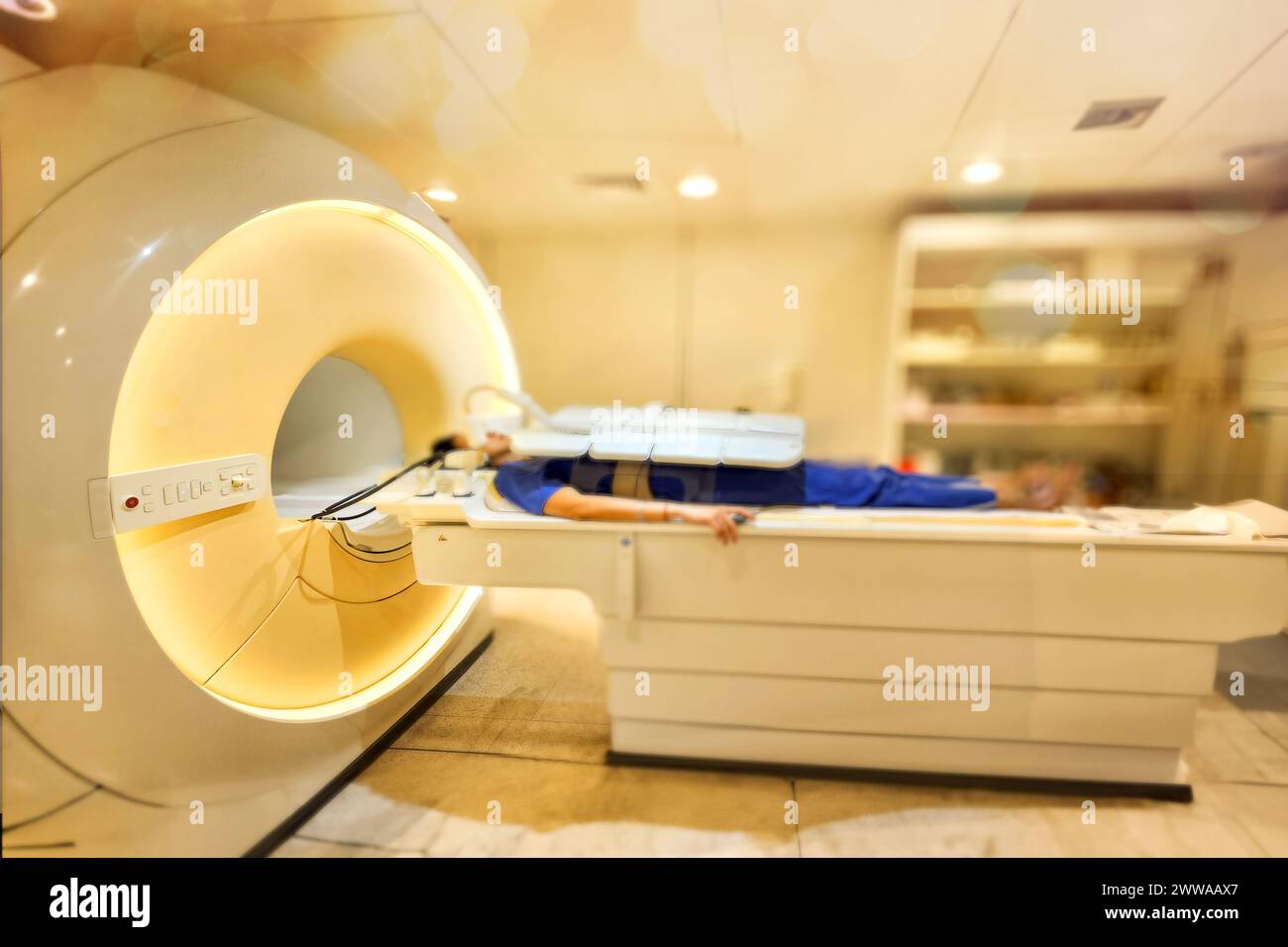 A patient lies down comfortably on the MRI scanner, undergoing a relaxing MRI scan to assess the upper abdomen, providing crucial medical insights. Stock Photo