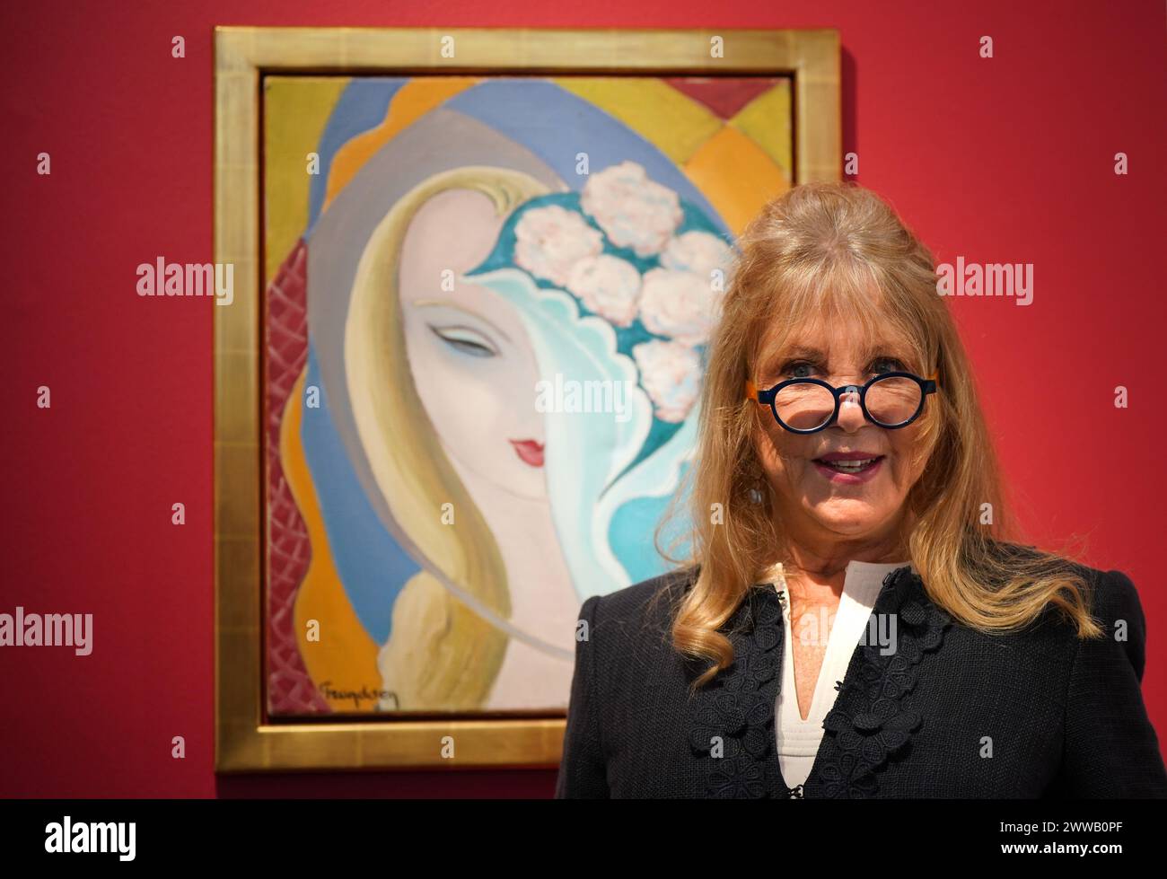 File photo dated 14/3/2024 of Pattie Boyd with La Jeune Fille au Bouquet, by Emile Theodore Frandsen de Schomberg, circa 1950-55, the original painting used as the cover artwork for the 1970 Derek and the Dominos album Layla and Other Assorted Love Songs. A trove of treasures from the former fashion model, including photographs and love letters, have sold for almost £3 million at auction - far exceeding its original estimate. The Pattie Boyd Collection included letters from the time she was involved in a love triangle with former husbands Eric Clapton and George Harrison. Issue date: Saturday  Stock Photo
