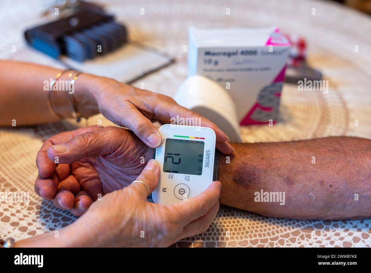 Nurse for home care of a 90-year-old senior, taking blood pressure. Stock Photo