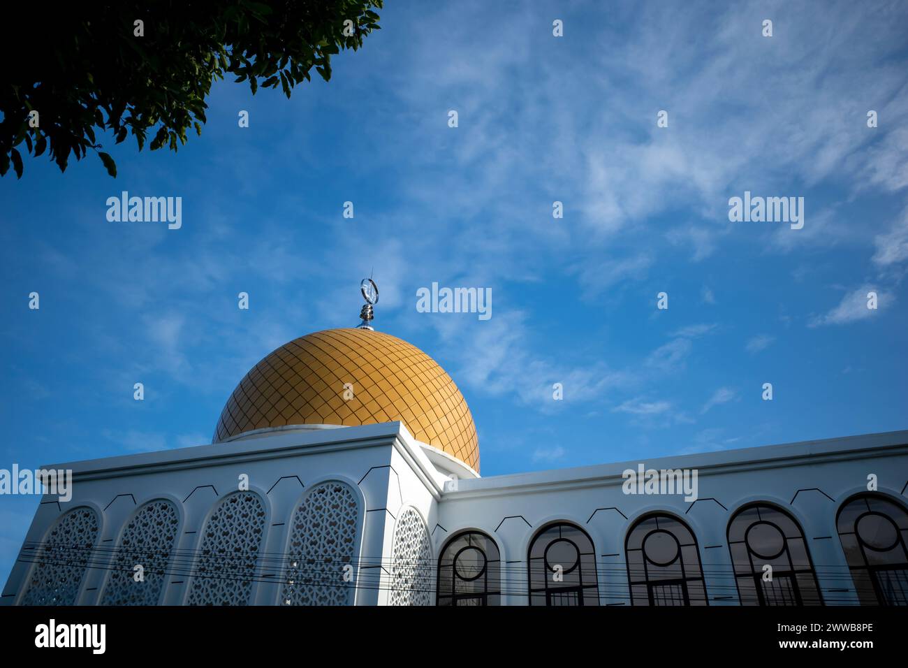 Kubah Masjid. A mosque with a beautiful yellow dome in Yogyakarta, Indonesia with blue sky background. Stock Photo