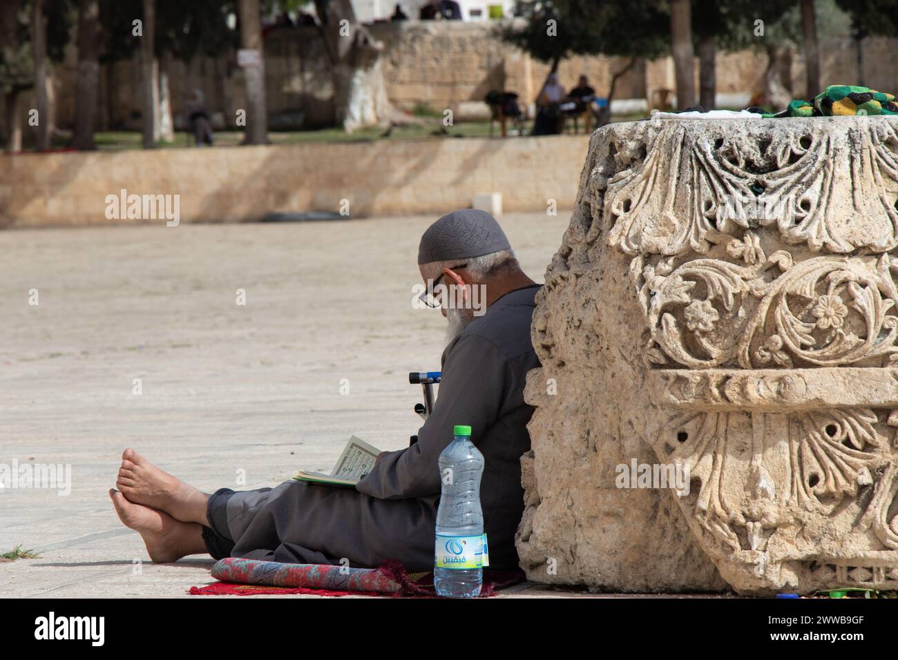 Old man reading Quran in Aqsa mosque during Ramadan. Al-Aqsa Mosque in the old city of Jerusalem - Palestine: 23 April 2022 Stock Photo