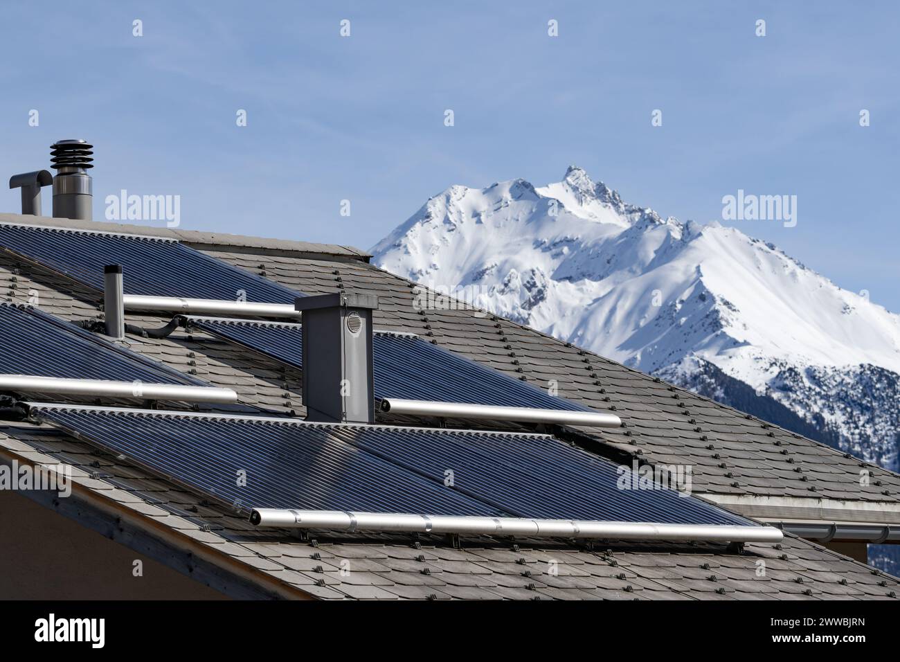 Solar tube collectors on the roof of a residential building in the Swiss Alps Stock Photo