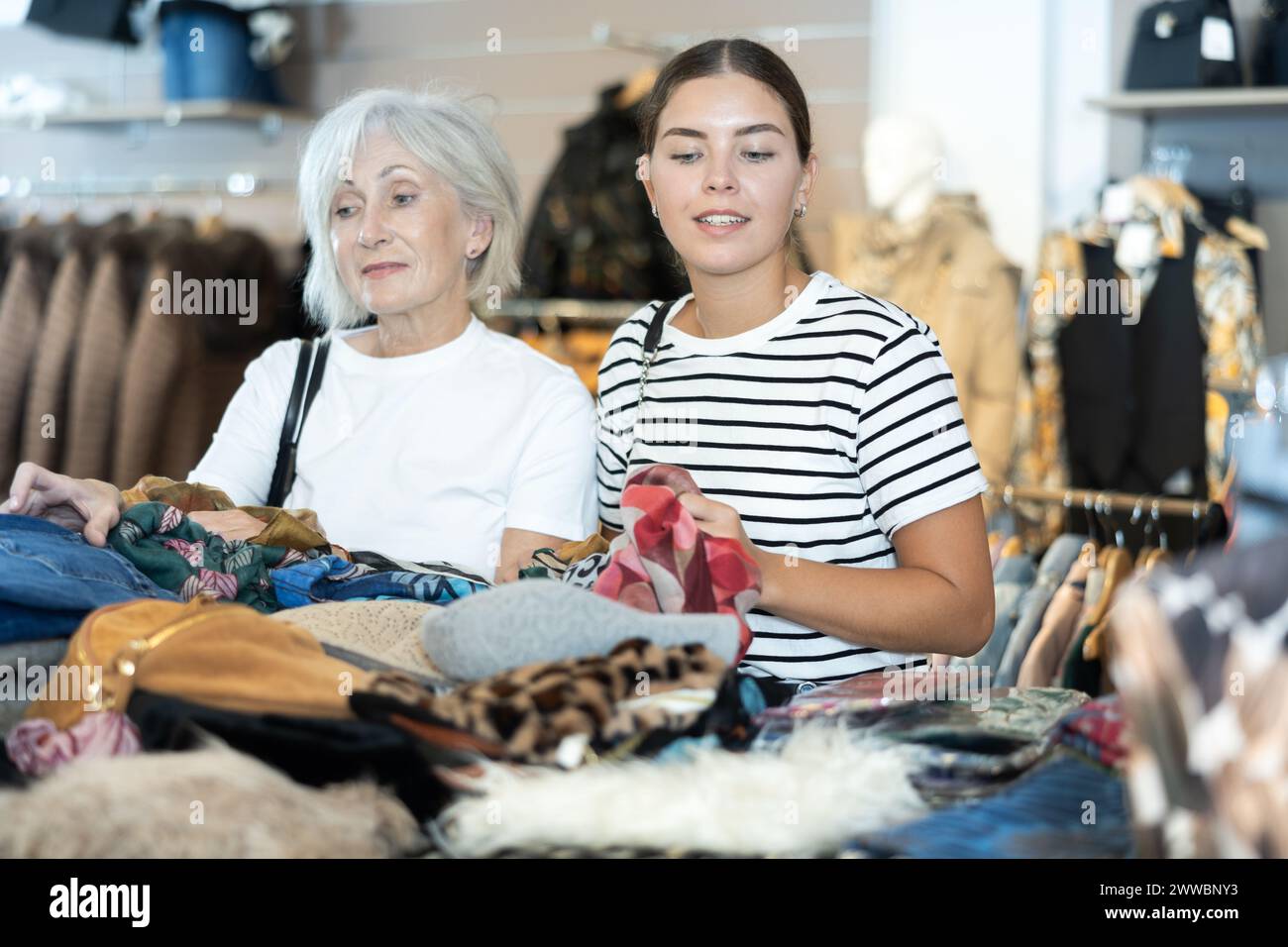 Women carefully examine secondhand clothes Stock Photo