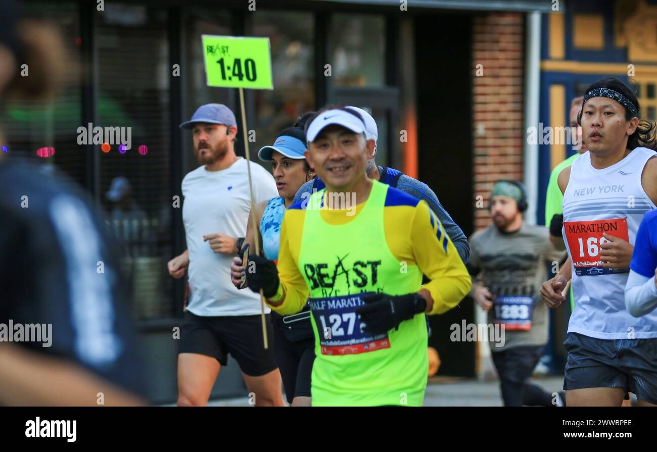 Babylon, New York, USA - 22 October 2023: Half marathon pace setter carrying a 1:40 sign to help the group run theit best half marathon. Stock Photo